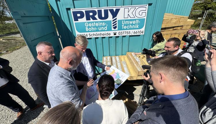 Mehrere Personen stehen um einen Karte herum